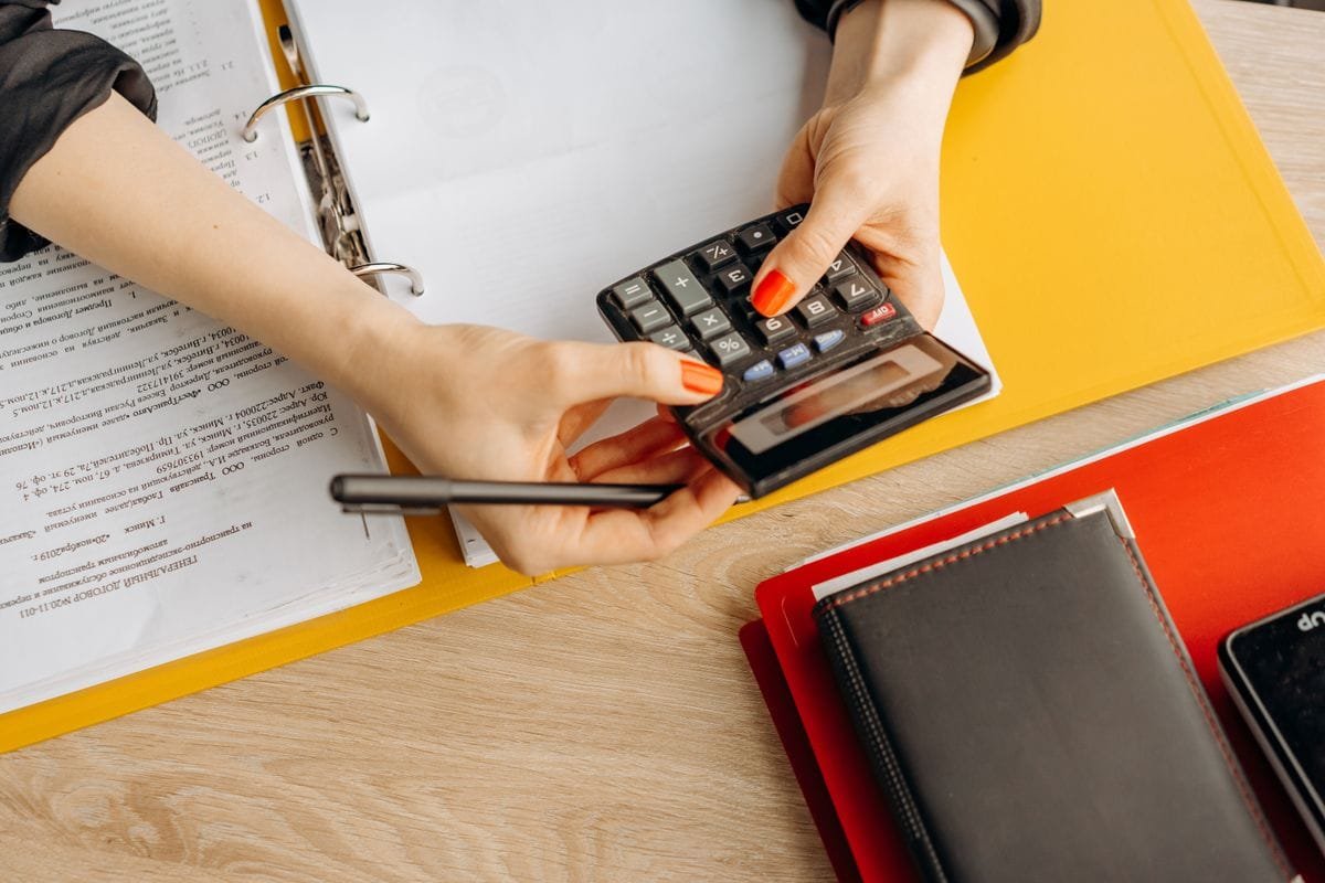 Hands using a calculator over financial documents